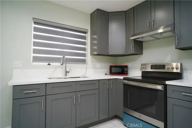 a kitchen with cabinets appliances a sink and a window