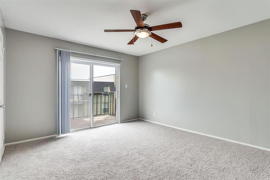 an empty room with ceiling fan and windows