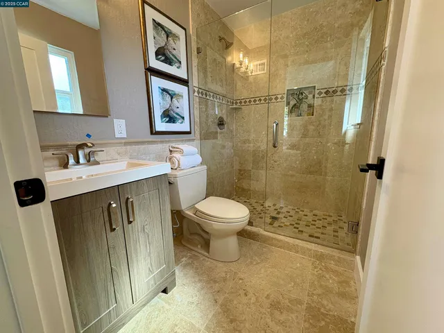 a bathroom with a granite countertop sink toilet a mirror and shower