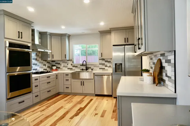 a kitchen with white cabinets and stainless steel appliances