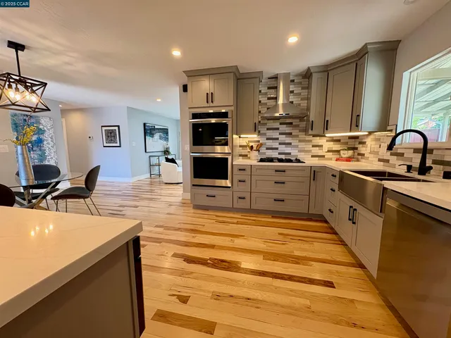 a large kitchen with kitchen island a sink stainless steel appliances and cabinets