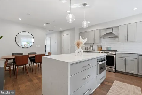 a kitchen with granite countertop a stove and a wooden floors