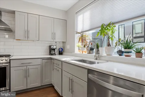 a kitchen with a stove and a wooden floor