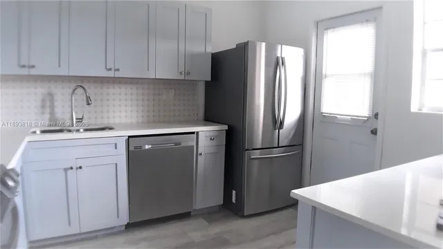 a kitchen with a refrigerator sink and cabinets