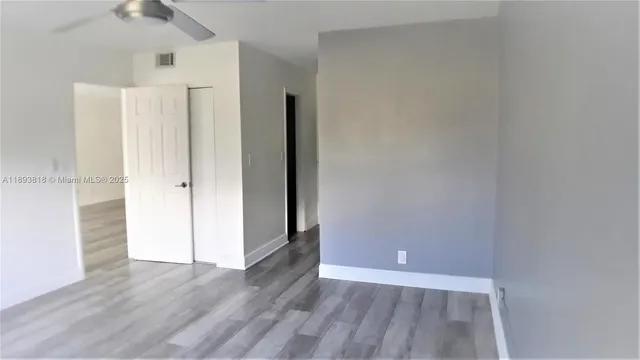 a view of an empty room with wooden floor