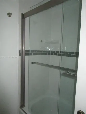 a bathroom with a glass shower door