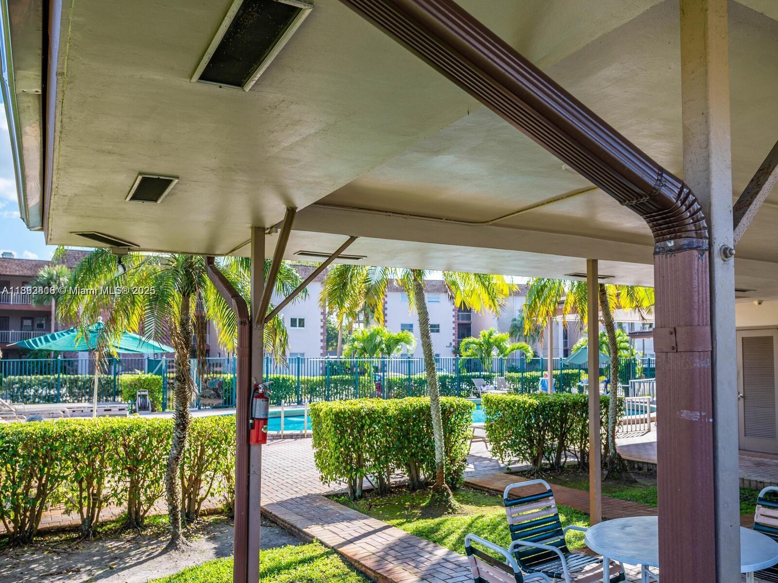 8101 Southwest 24th Court, Unit 206 Davie, FL 33324 - Photo 38 of 41 a patio with yard glass top table and chairs