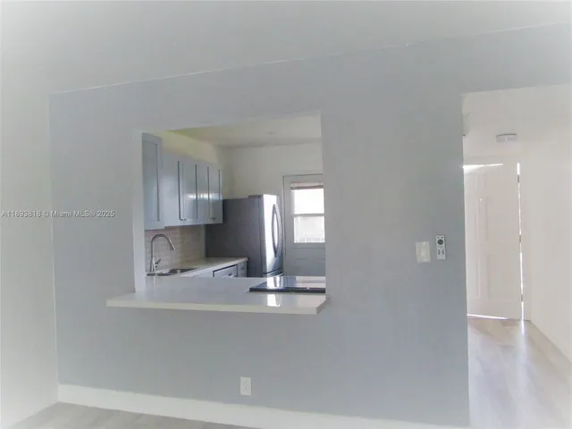 a kitchen with a refrigerator and window