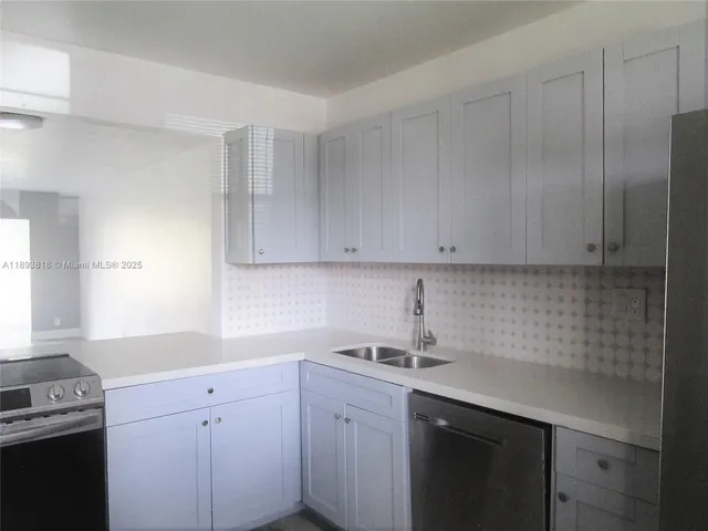 a kitchen with a sink cabinets and window