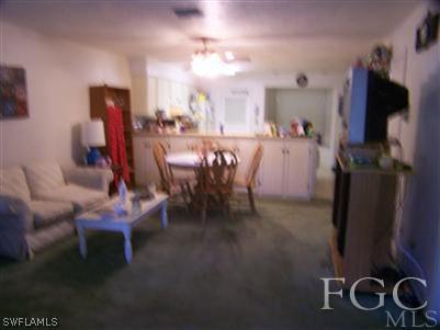 1602 Ridgecrest Street Lehigh Acres, FL 33936 - Photo 8 of 12 a view of a dining room with furniture and a flat screen tv