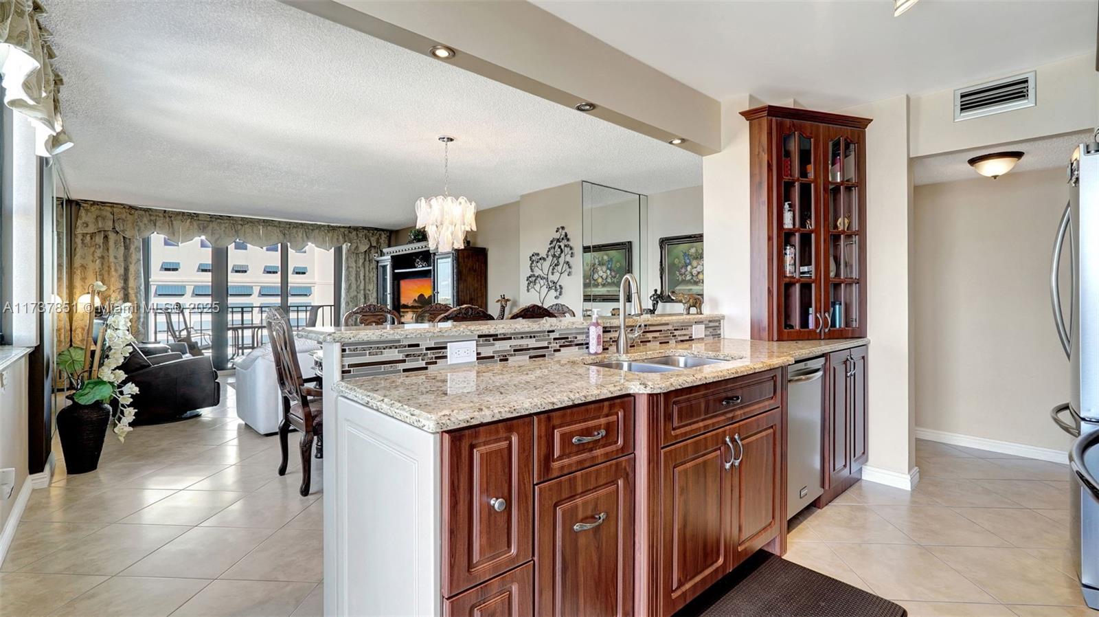 322 Buchanan Street, Unit 907 Hollywood, FL 33019 - Photo 12 of 45 a kitchen with kitchen island granite countertop a sink stove and cabinets