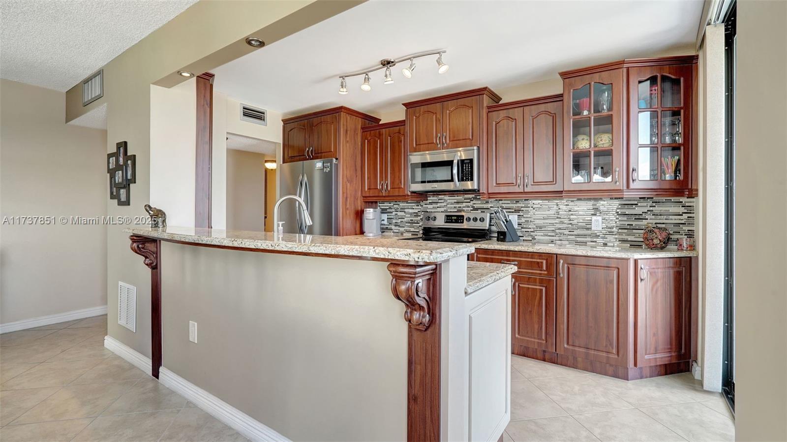 322 Buchanan Street, Unit 907 Hollywood, FL 33019 - Photo 13 of 45 a kitchen with stainless steel appliances granite countertop a refrigerator sink and cabinets