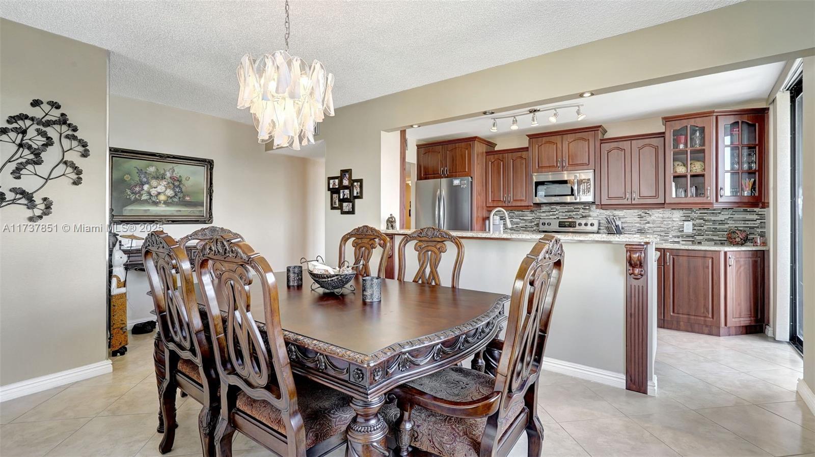 322 Buchanan Street, Unit 907 Hollywood, FL 33019 - Photo 14 of 45 a view of a dining room with furniture and chandelier