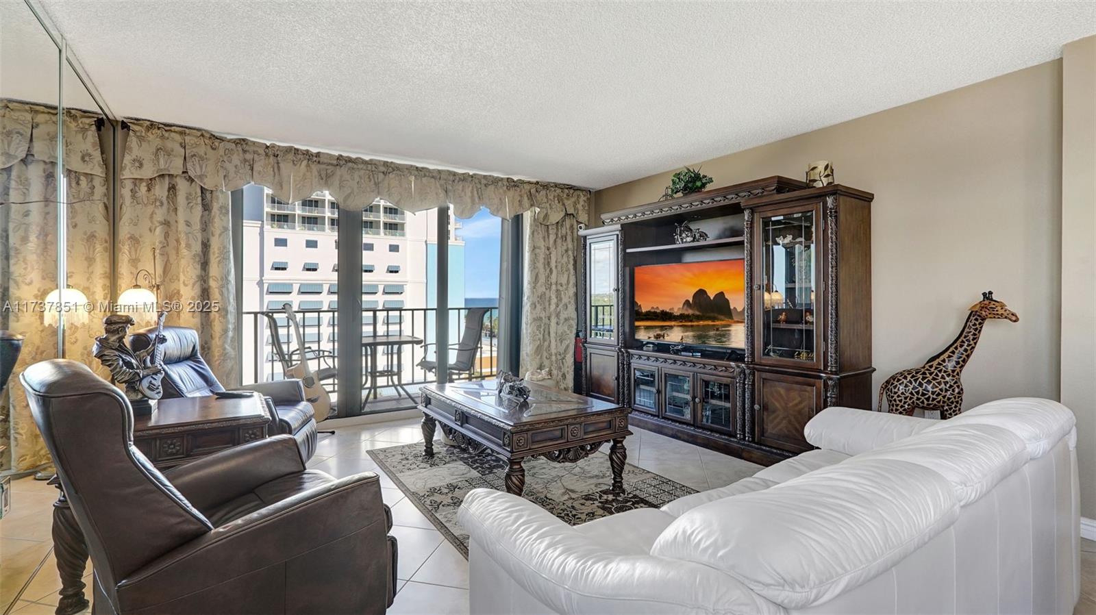 322 Buchanan Street, Unit 907 Hollywood, FL 33019 - Photo 20 of 45 a living room with furniture and a flat screen tv