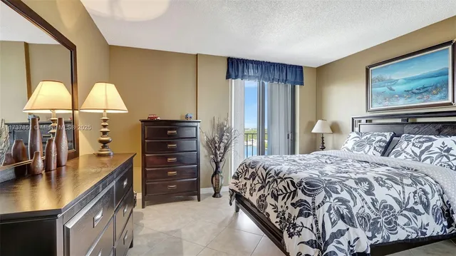 a bedroom with a bed and a lamp with the dresser