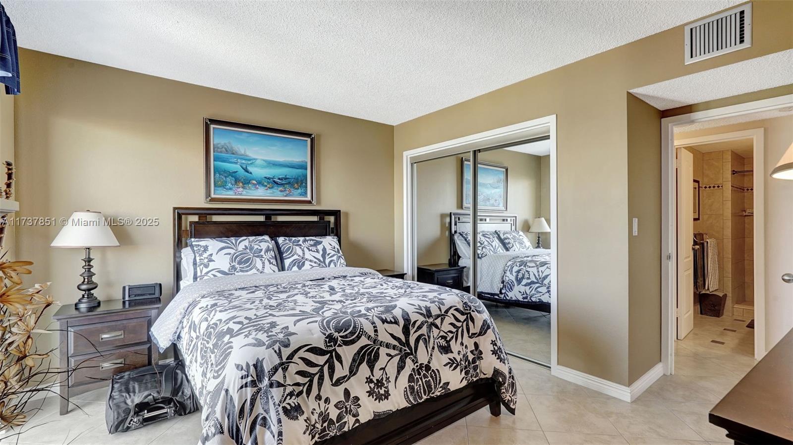 322 Buchanan Street, Unit 907 Hollywood, FL 33019 - Photo 22 of 45 a bedroom with a bed and a lamp with the dresser