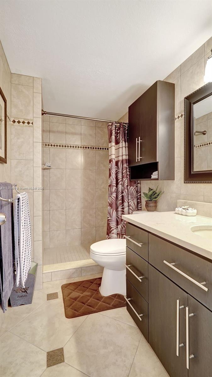 322 Buchanan Street, Unit 907 Hollywood, FL 33019 - Photo 24 of 45 a bathroom with a sink a toilet and a mirror