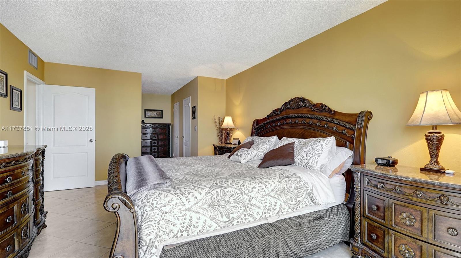 322 Buchanan Street, Unit 907 Hollywood, FL 33019 - Photo 28 of 45 a bedroom with a bed and dresser with mirror