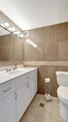 a living room with furniture and potted plants with wooden floor