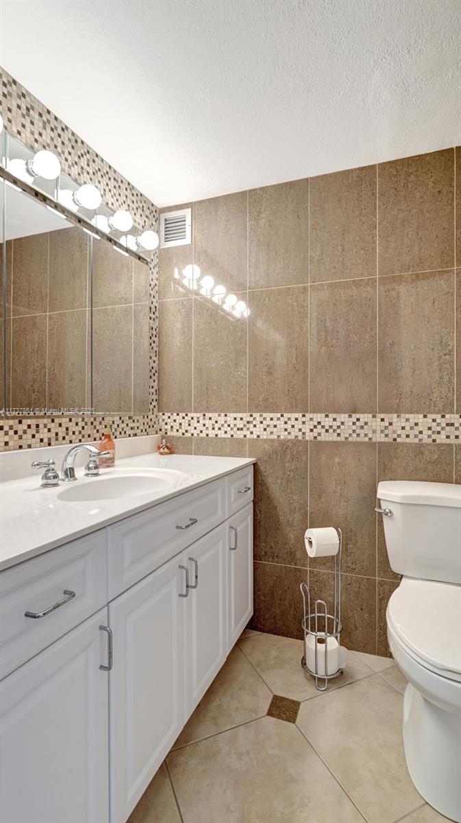 322 Buchanan Street, Unit 907 Hollywood, FL 33019 - Photo 31 of 45 a bathroom with a toilet a sink and mirror