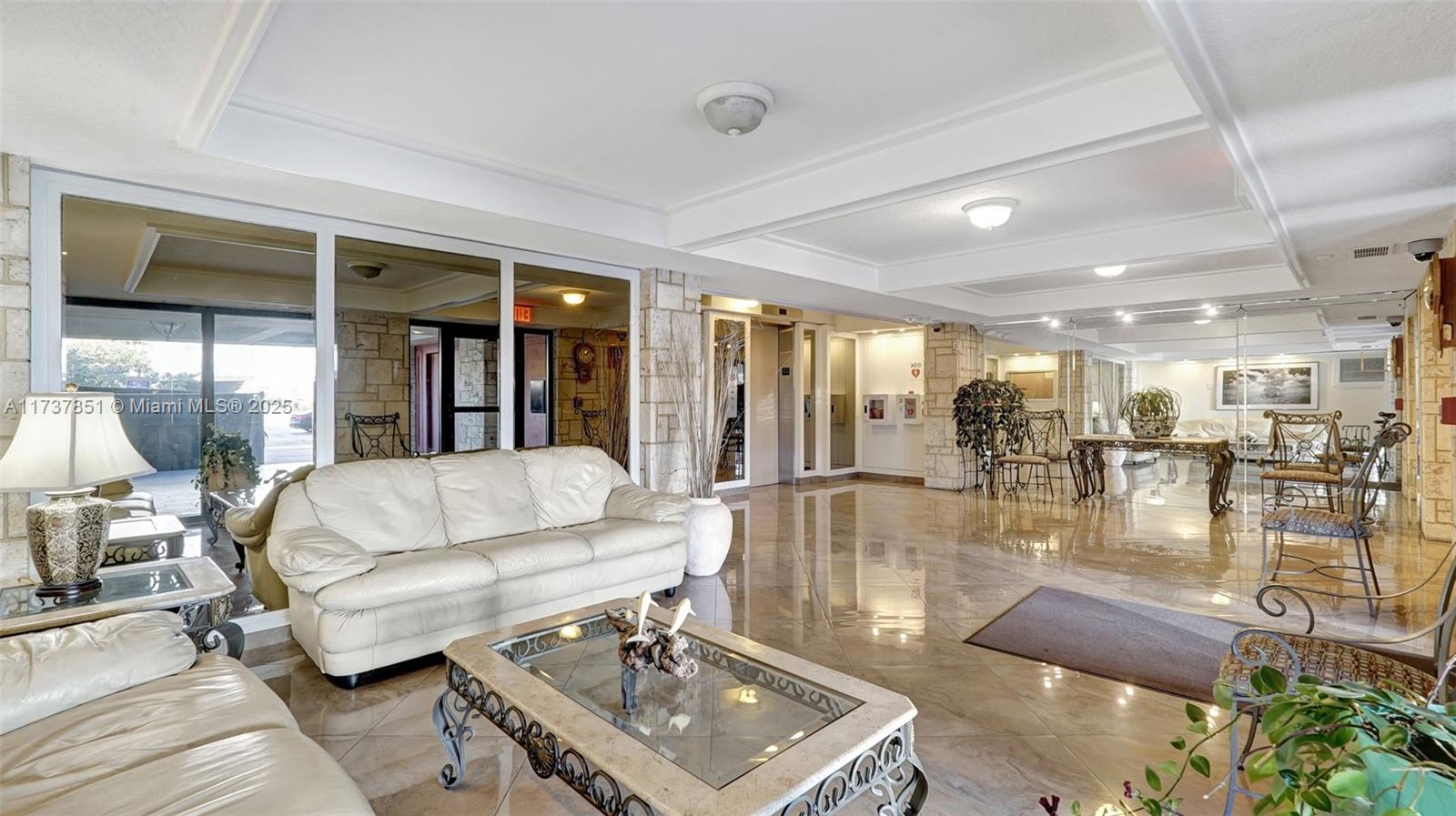 322 Buchanan Street, Unit 907 Hollywood, FL 33019 - Photo 34 of 45 a living room with couches and kitchen view with wooden floor
