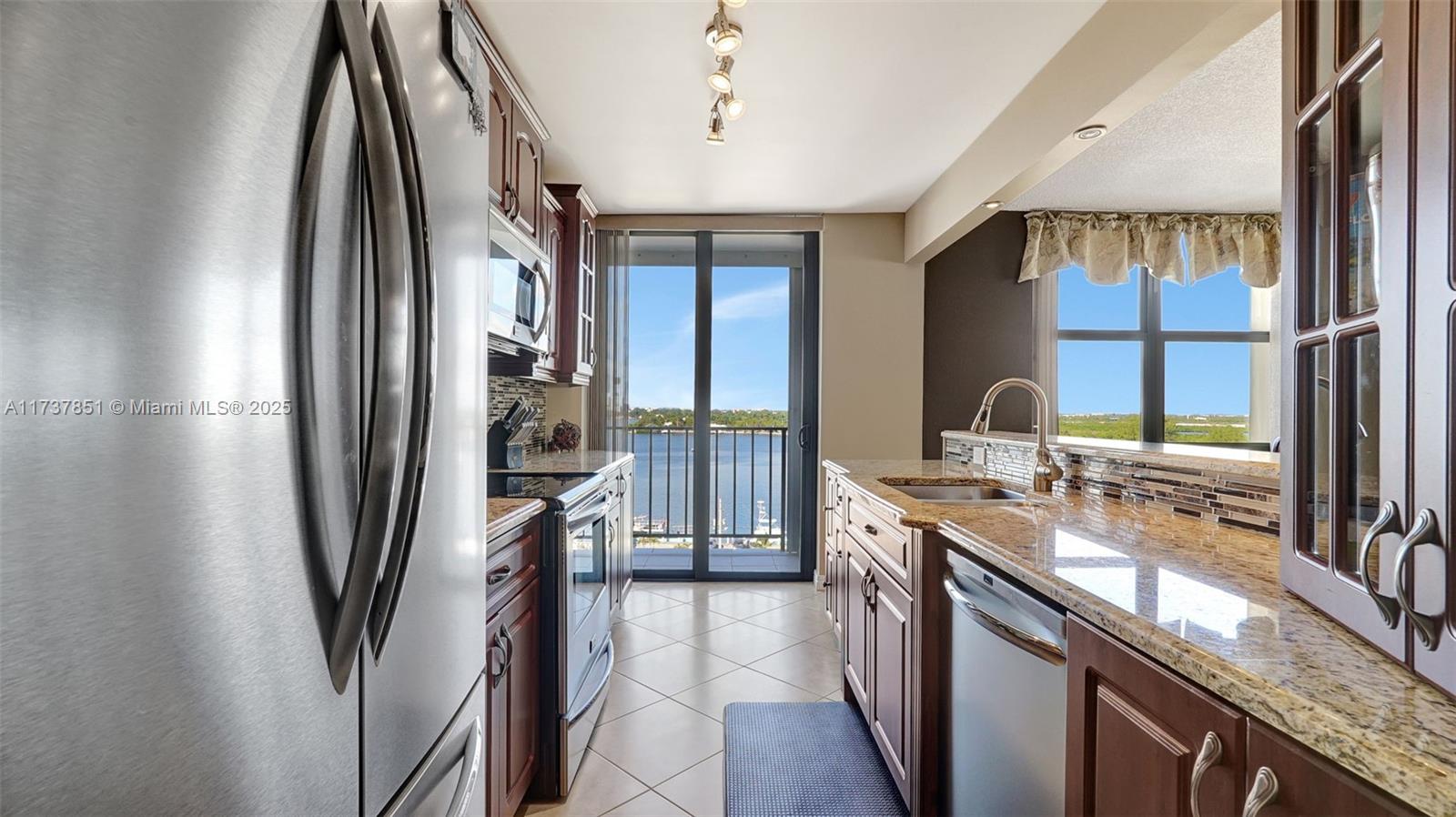 322 Buchanan Street, Unit 907 Hollywood, FL 33019 - Photo 7 of 45 a kitchen with stainless steel appliances granite countertop a refrigerator and a sink