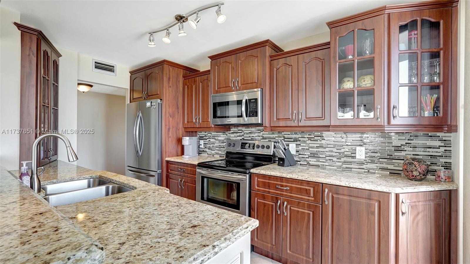 322 Buchanan Street, Unit 907 Hollywood, FL 33019 - Photo 10 of 45 a kitchen with stainless steel appliances granite countertop a sink stove and refrigerator