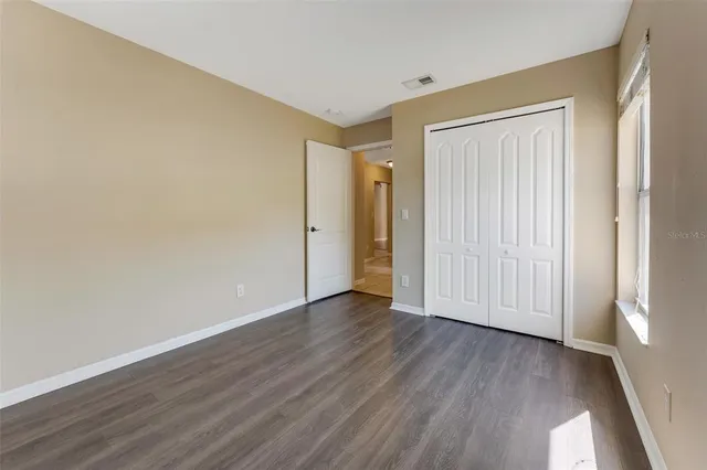 an empty room with wooden floor and a window
