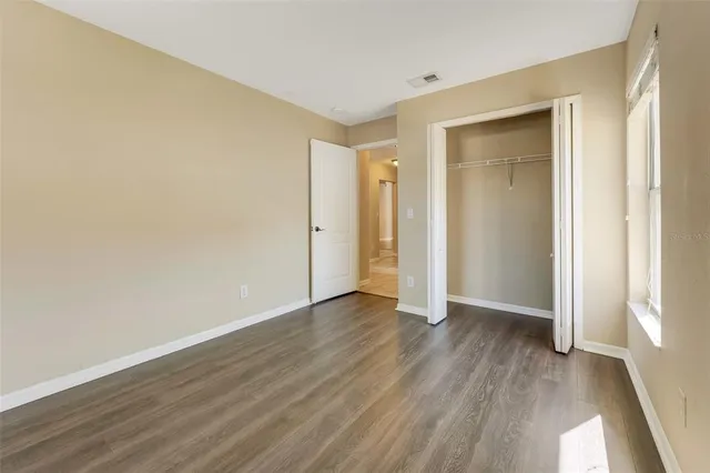 an empty room with wooden floor and closet