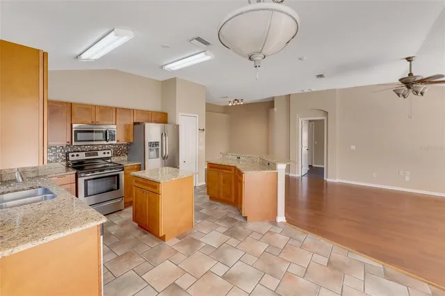 a kitchen with stainless steel appliances a stove refrigerator and microwave