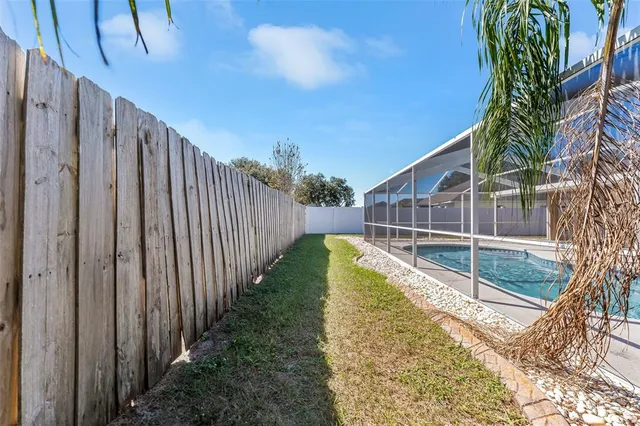 a view of a backyard with wooden fence