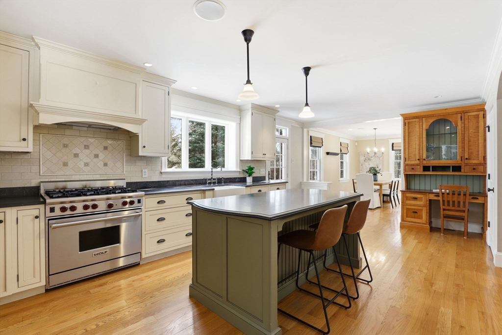 138 Judge Cushing Road Scituate, MA 02066 - Photo 4 of 40 a kitchen with stainless steel appliances granite countertop a stove a sink dishwasher a dining table and chairs with wooden floor
