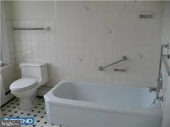 a white toilet sitting next to a bath tub