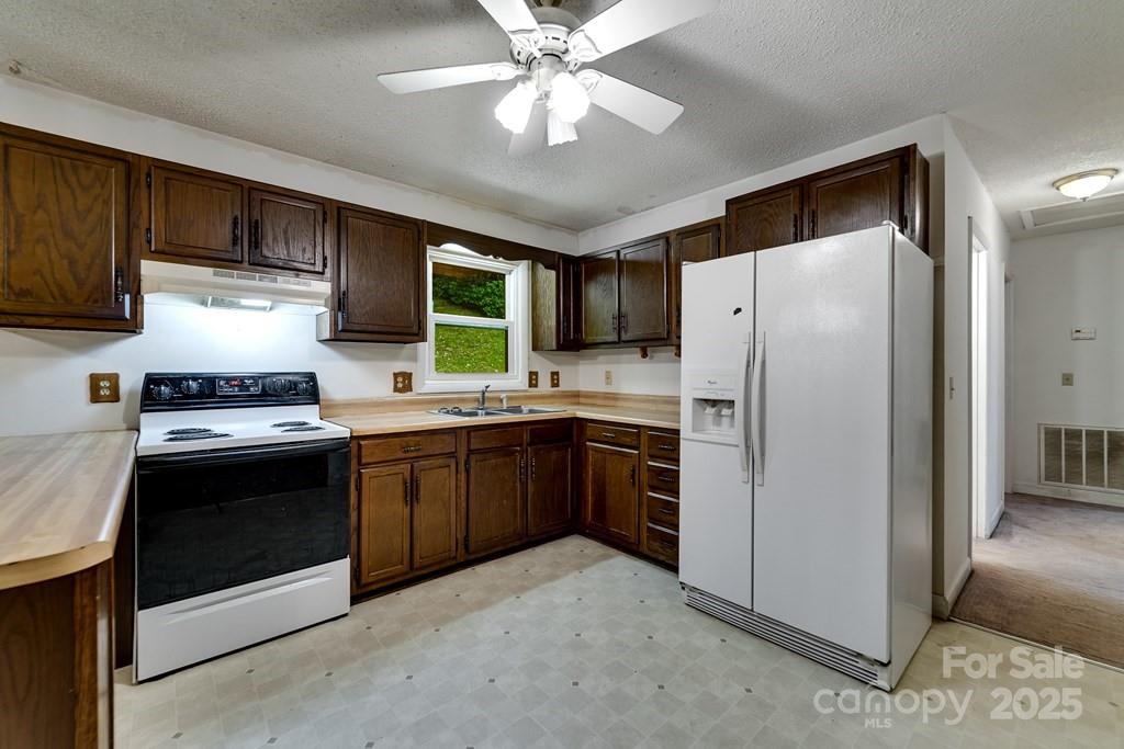 302 Mitchell Road Sylva, NC 28779 - Photo 15 of 48 a kitchen with stainless steel appliances granite countertop a refrigerator a stove a sink and a dining table with wooden floor