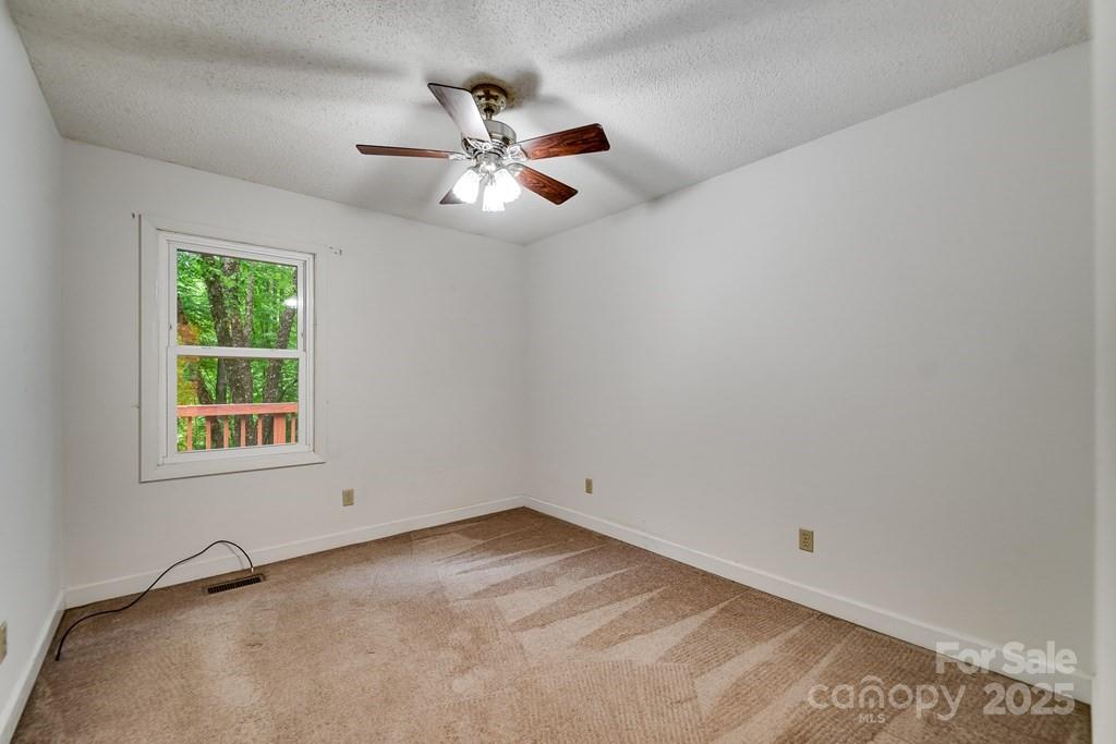 302 Mitchell Road Sylva, NC 28779 - Photo 19 of 48 an empty room with windows and chandelier fan