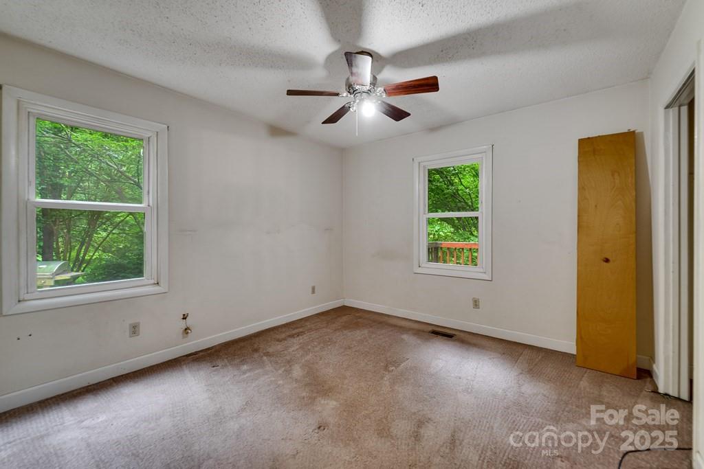 302 Mitchell Road Sylva, NC 28779 - Photo 23 of 48 a view of an empty room with window and chandelier fan