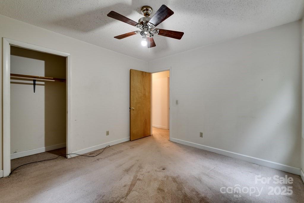 302 Mitchell Road Sylva, NC 28779 - Photo 24 of 48 an empty room with closet and a chandelier fan