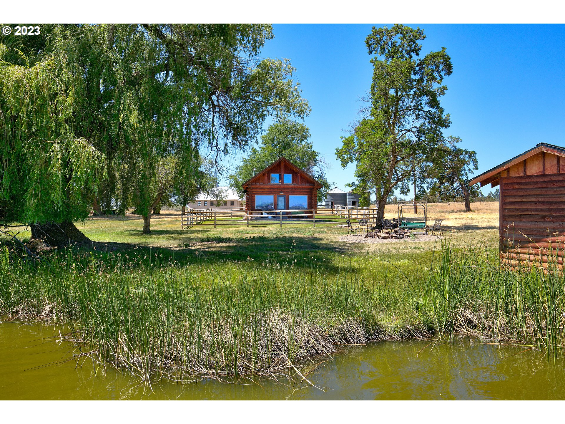 11677 Southwest Houston Lake Road Powell Butte, OR 97753 - Photo 17 of 35 a view of swimming pool with lawn chairs and plants