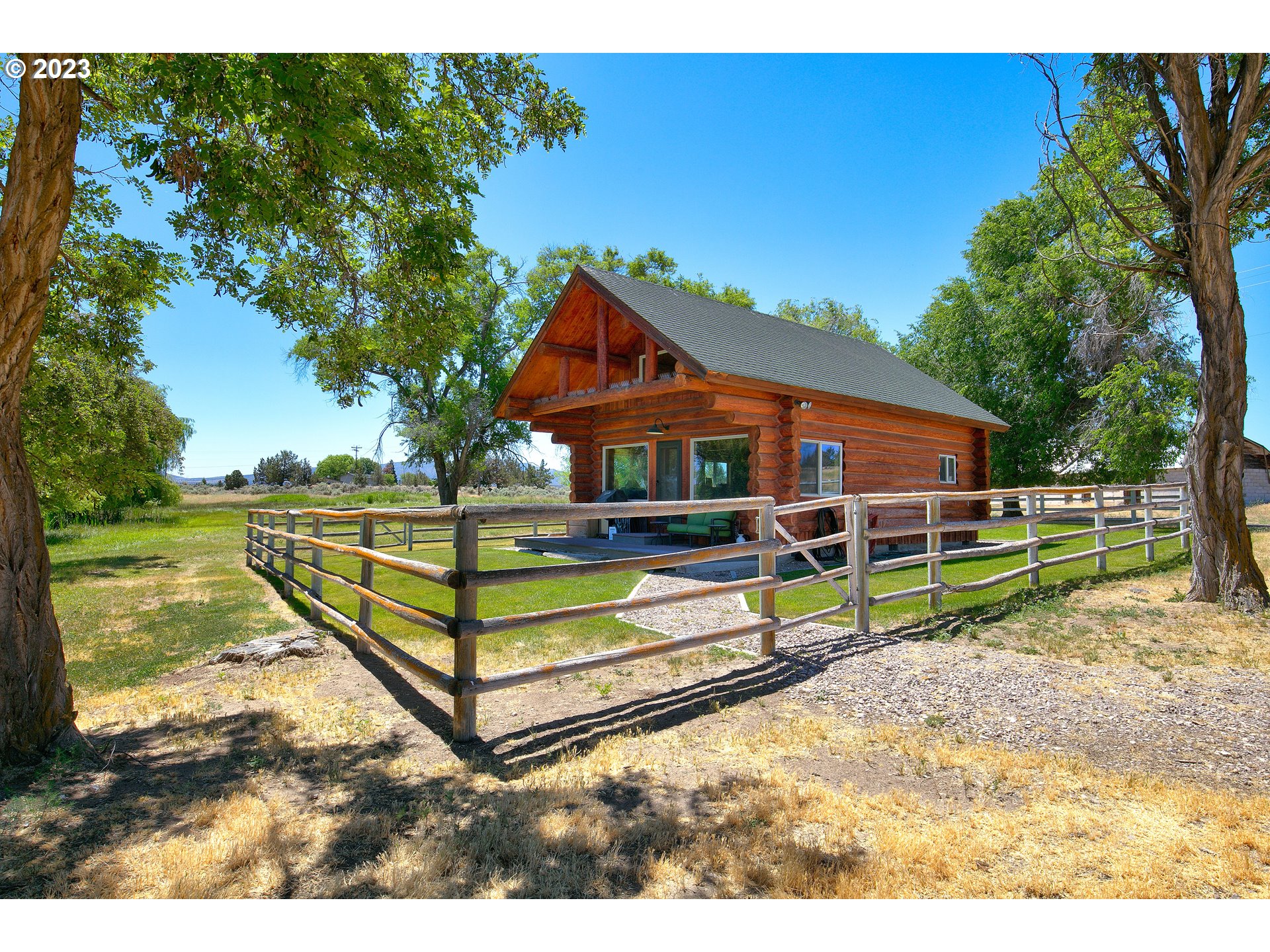 11677 Southwest Houston Lake Road Powell Butte, OR 97753 - Photo 5 of 35 a view of an house with backyard and a tree