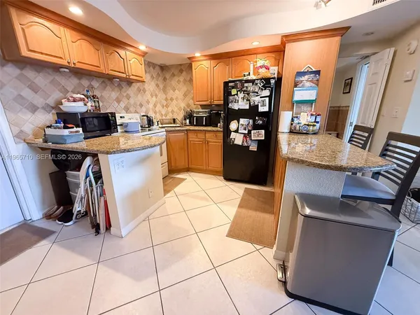 a kitchen with stainless steel appliances kitchen island granite countertop a refrigerator and a stove