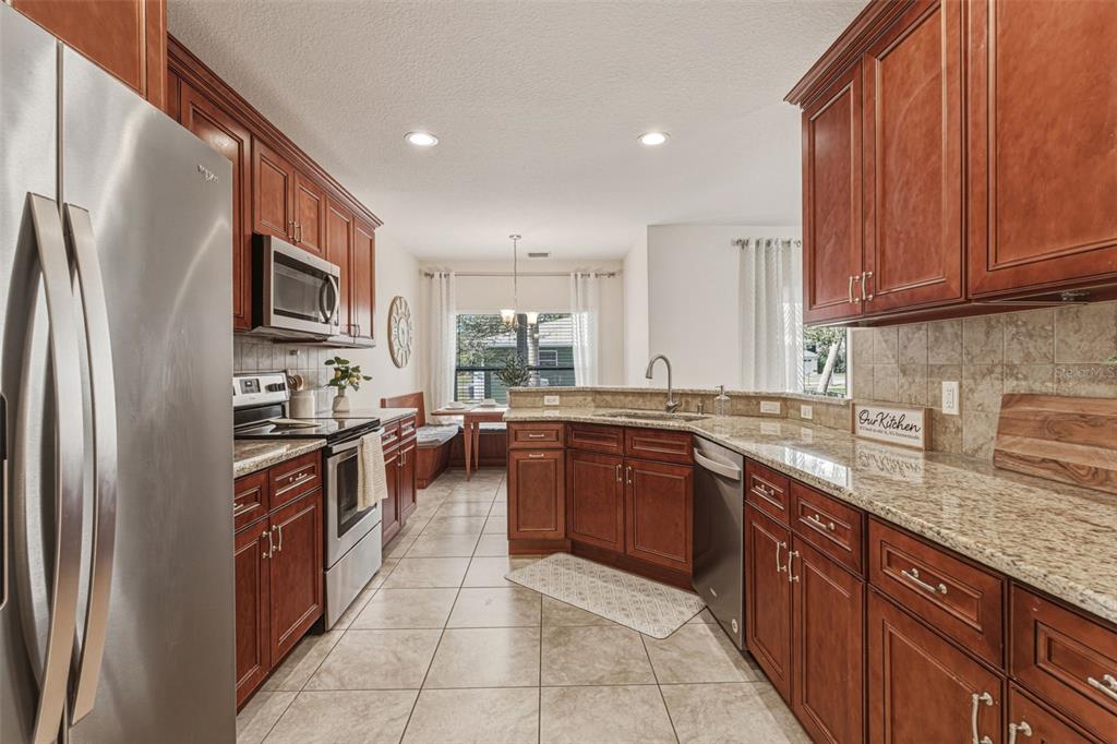 634 Carmel Road Venice, FL 34293 - Photo 15 of 67 a large kitchen with stainless steel appliances granite countertop a stove top oven a sink and dishwasher