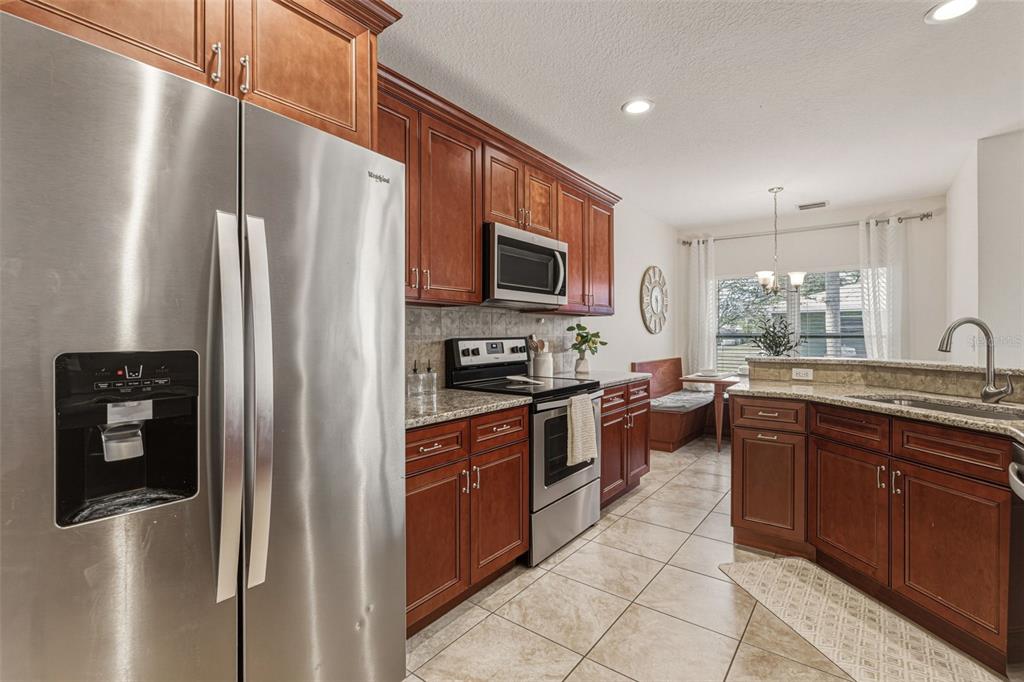 634 Carmel Road Venice, FL 34293 - Photo 17 of 67 a kitchen with stainless steel appliances granite countertop a refrigerator a stove top oven and sink