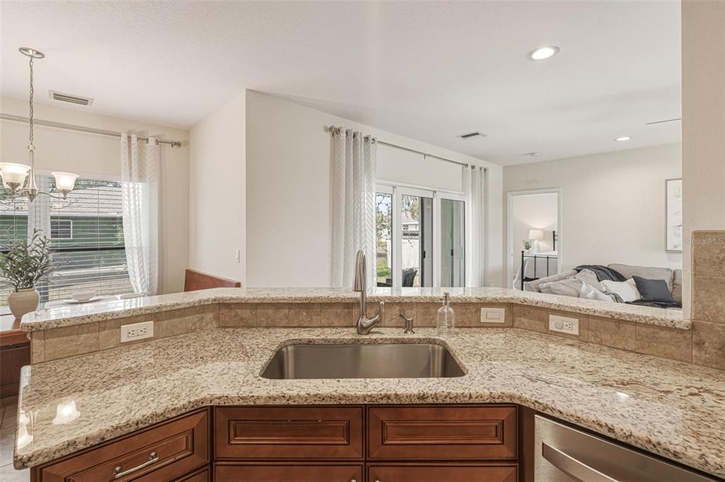 634 Carmel Road Venice, FL 34293 - Photo 18 of 67 a kitchen with a granite countertop sink and natural light