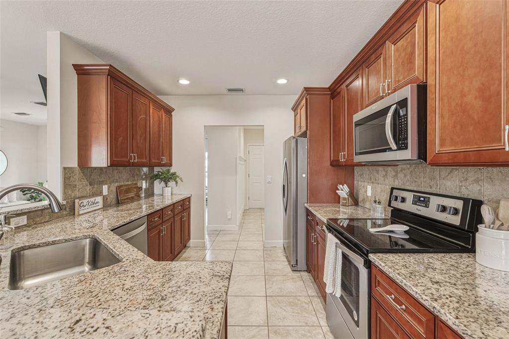 634 Carmel Road Venice, FL 34293 - Photo 19 of 67 a kitchen with stainless steel appliances granite countertop a sink stove and refrigerator