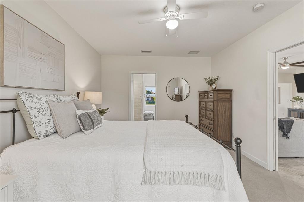 634 Carmel Road Venice, FL 34293 - Photo 24 of 67 a bedroom with a large bed and a chandelier