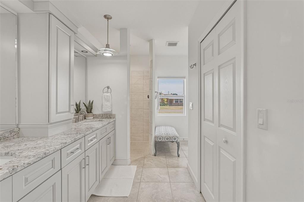 634 Carmel Road Venice, FL 34293 - Photo 27 of 67 a spacious bathroom with a granite countertop sink a mirror and a shower