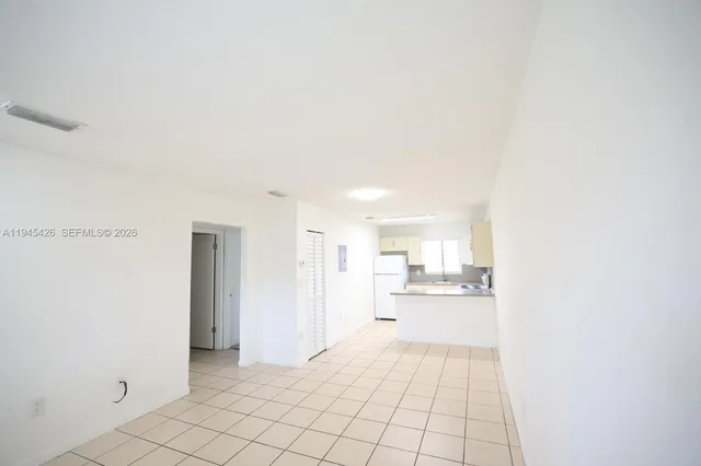 a view of a kitchen with a sink and an empty room