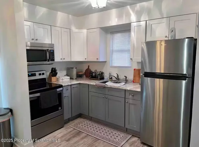 a kitchen with stainless steel appliances granite countertop a refrigerator sink and stove