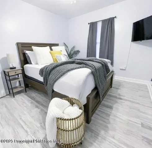 a spacious bedroom with a bed and a flat screen tv