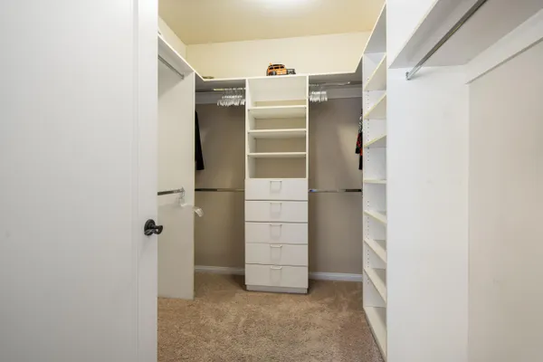 a view of walk in closet with clothes
